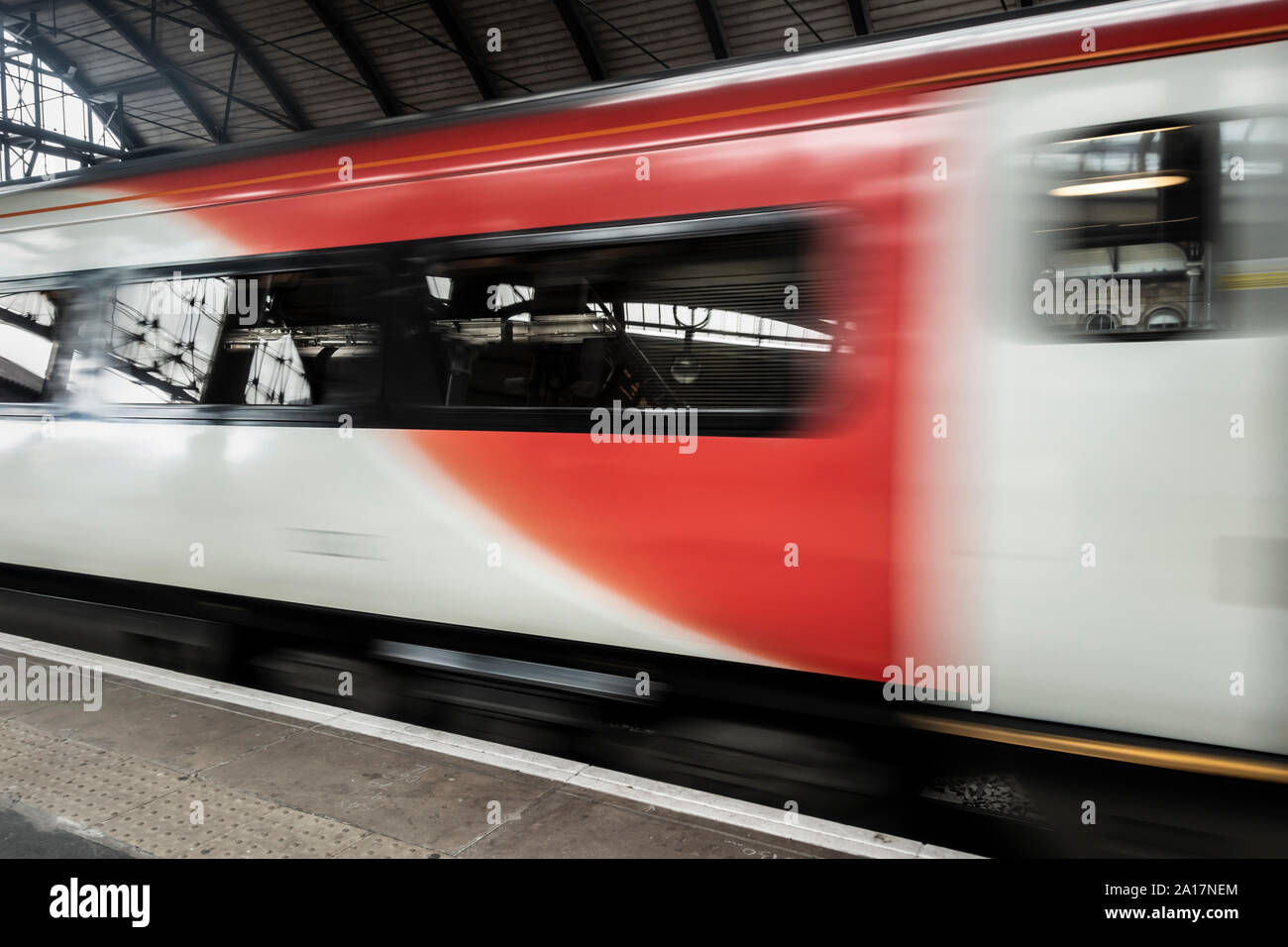 Accelerando il passaggio del treno stazione ferroviaria piattaforma. Regno Unito Foto Stock
