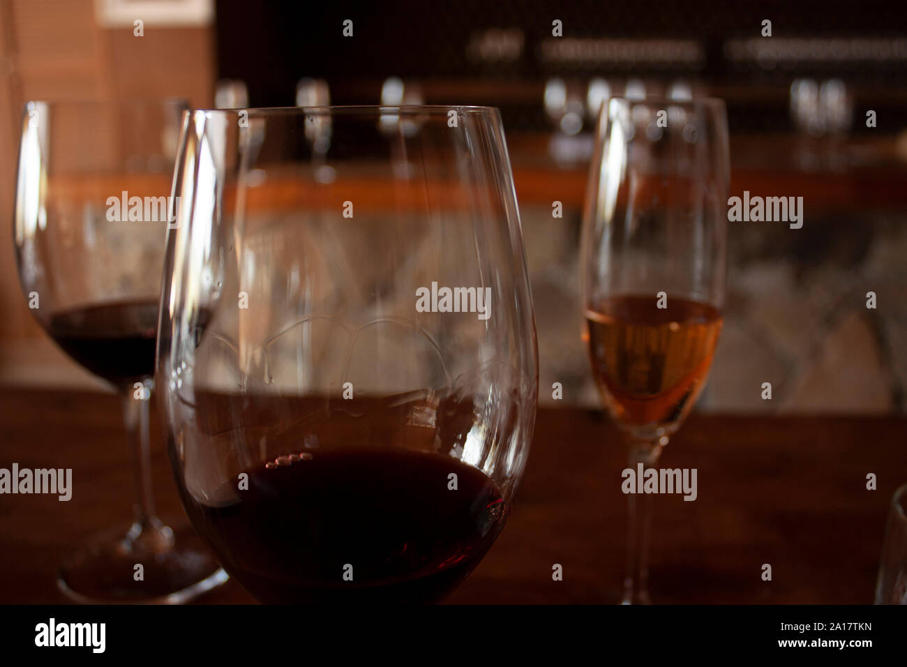 Il trio di occhiali per degustare vino vetro anteriore con il vino rosso a densità di prova con le gambe o le lacrime che forma in vetro Foto Stock