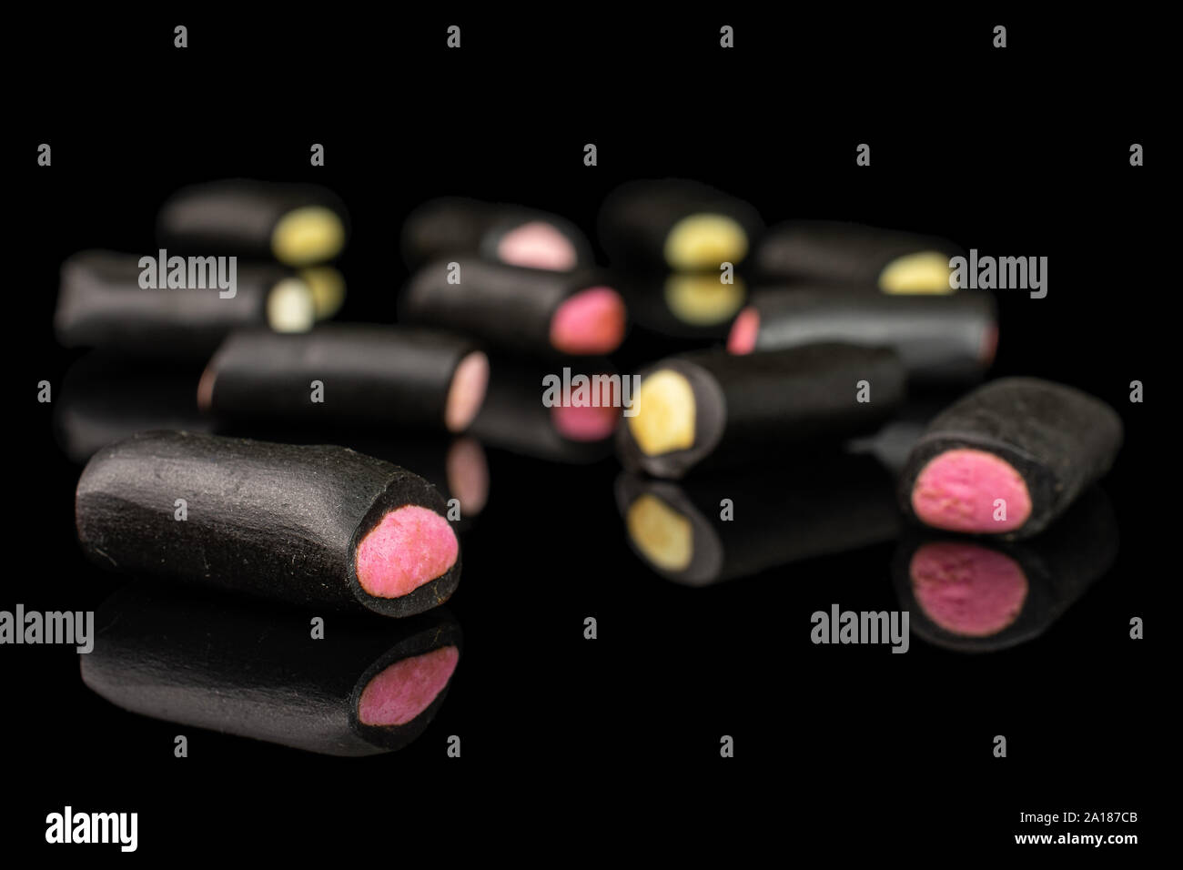Sacco di tutto il dolce di liquirizia nera candy isolato sul vetro nero Foto Stock