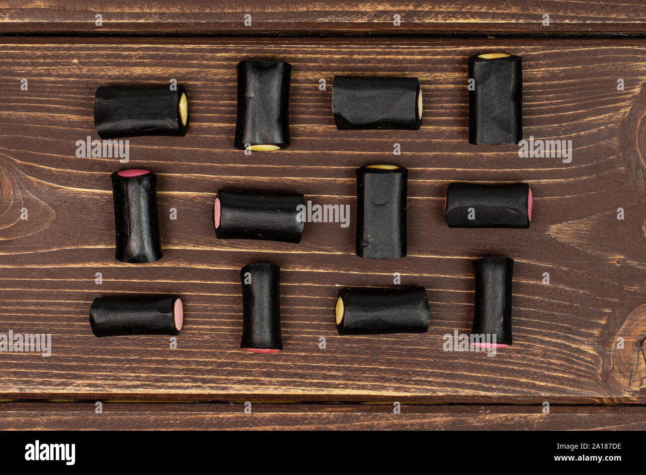 Sacco di tutto il dolce di liquirizia nera candy flatlay su legno marrone Foto Stock