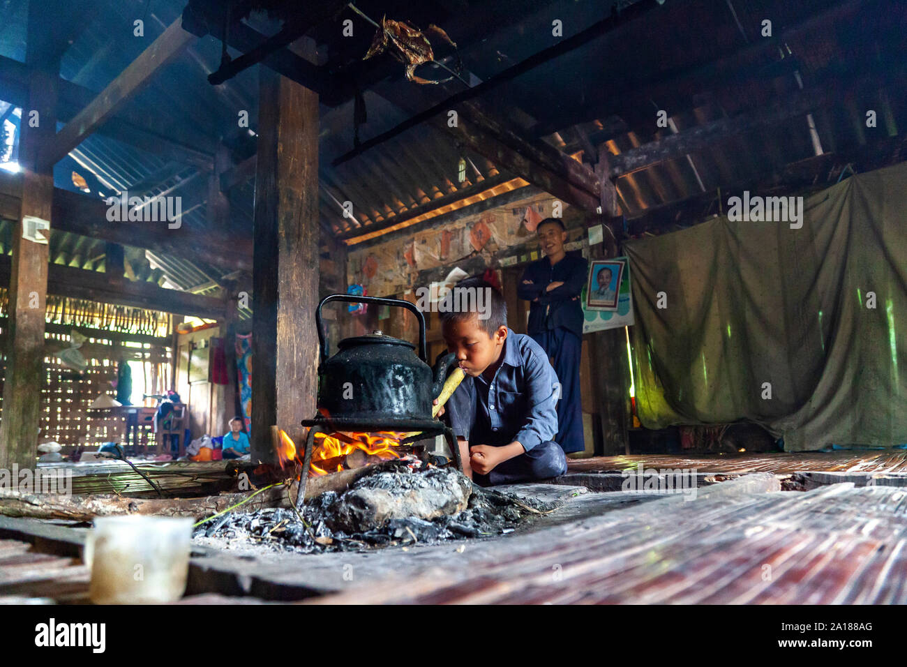 Ragazzo che frequentano il fuoco. In casa di una famiglia di minoranza di persone in Hoang Su Phi, in ettari Giang provincia, in zone montuose nordoccidentali del Vietnam. Foto Stock