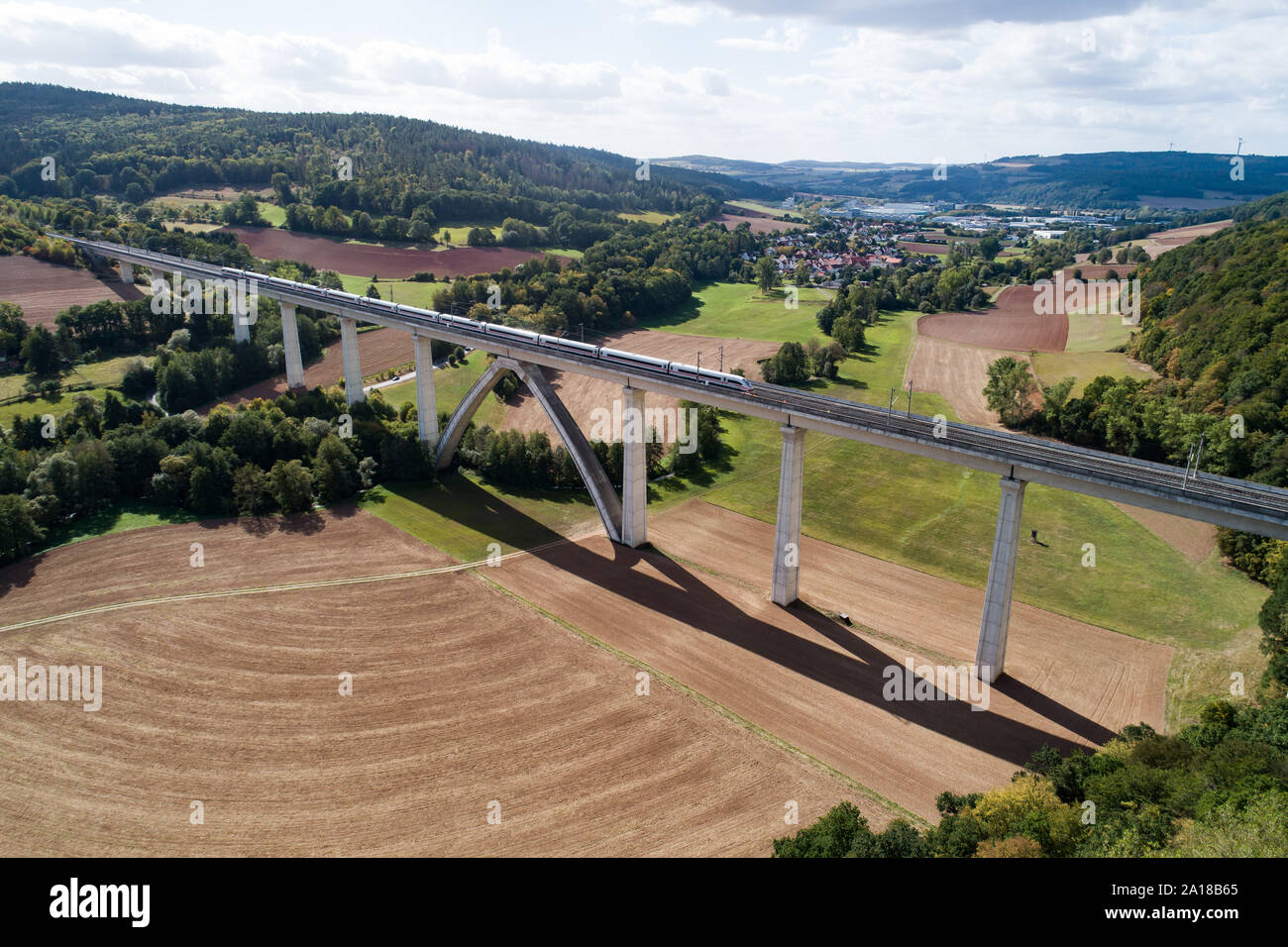 Germania. Xviii Sep, 2019. Un ICE della Deutsche Bahn viaggi sulla linea ad alta velocità tra Hannover e Würzburg su una pista con uno strato di vernice bianca sul ponte Pfieffetal. La ferrovia si avvia per la prima volta la prova pratica con rotaie di bianco contro gli effetti del calore durante il funzionamento. (Fotografia aerea con drone) Credito: Swen Pförtner/dpa/Alamy Live News Foto Stock