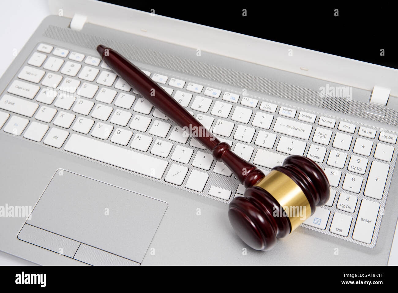 Giudice in legno martello su un argento computer laptop, cyber legge o asta online concetto. Foto Stock