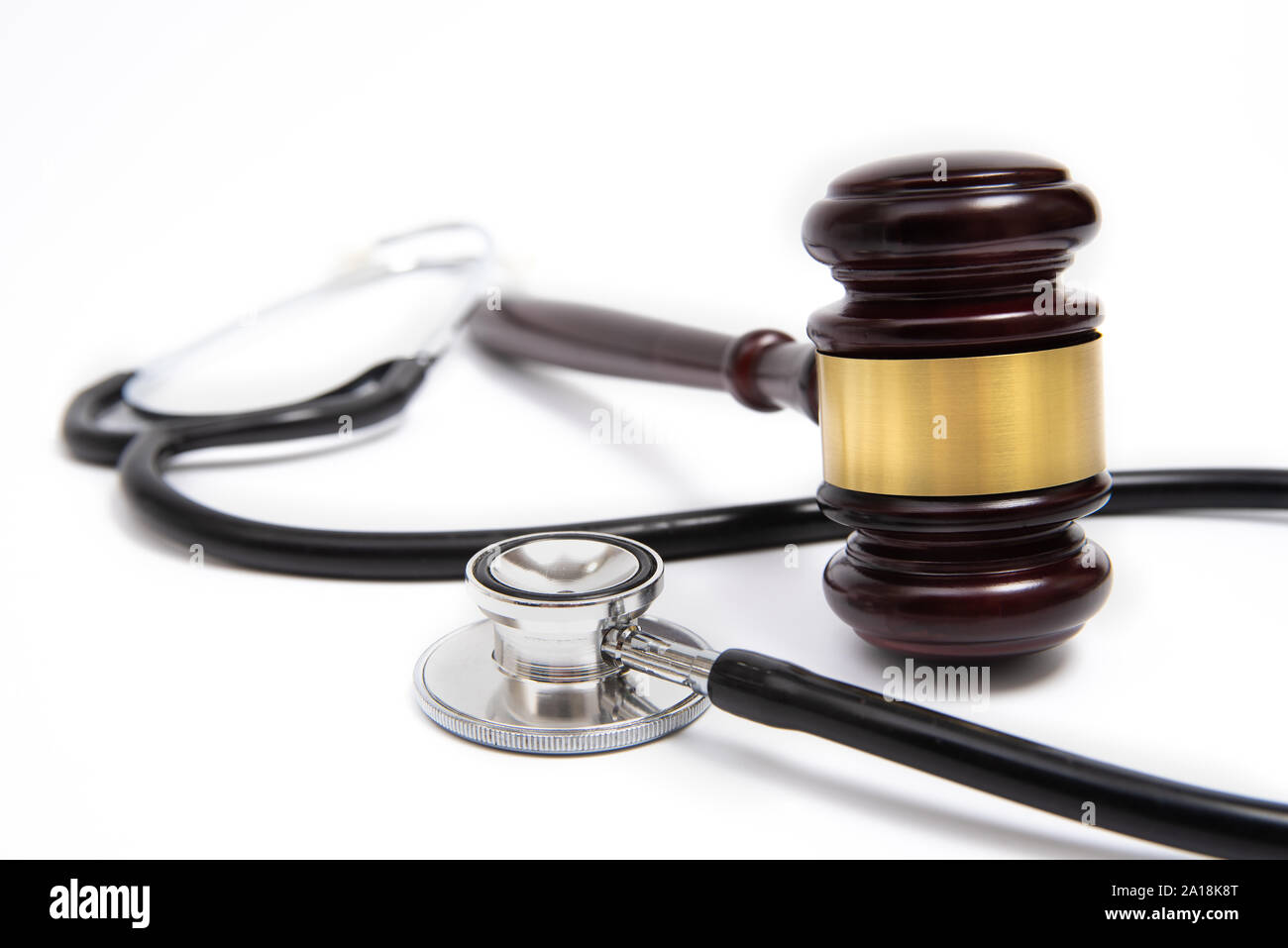 Un giudice in legno martello e uno stetoscopio isolati su sfondo bianco. Medical controversia concetto. Foto Stock
