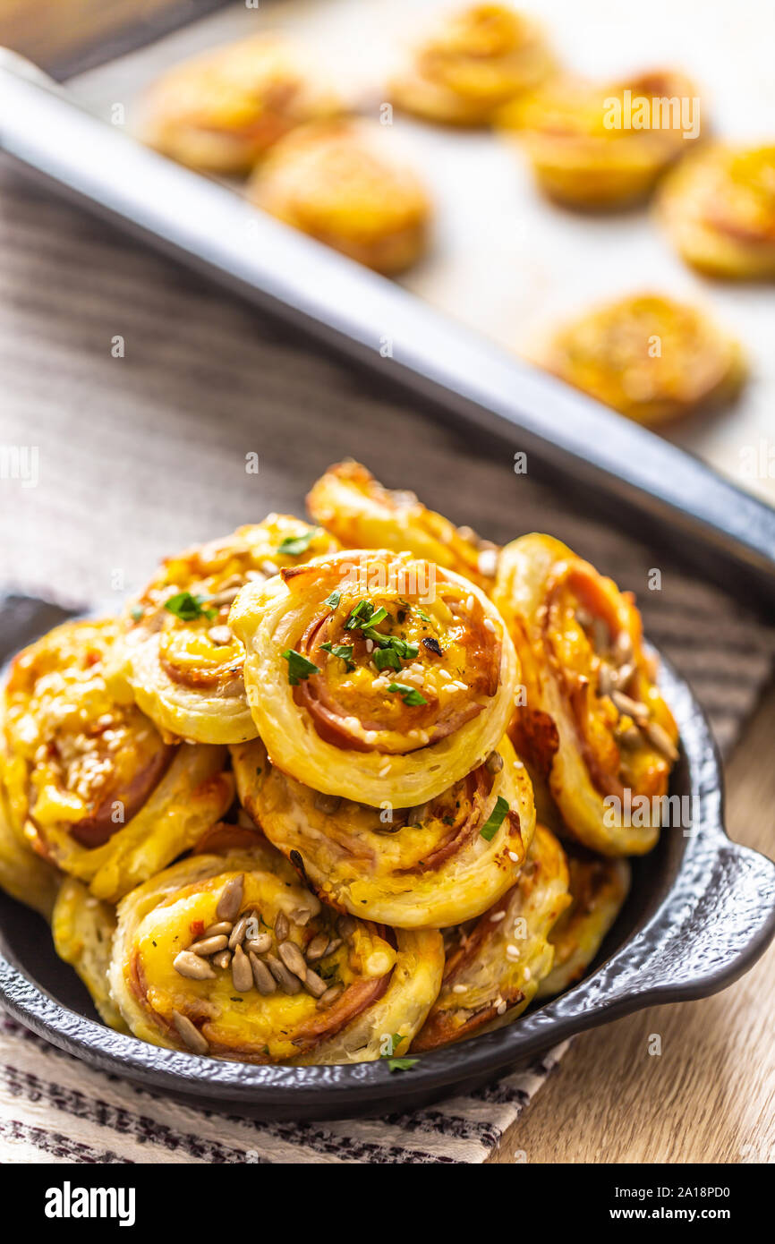 Rotoli di pasta sfoglia con prosciutto formaggio pancetta sesamo nel piatto Foto Stock