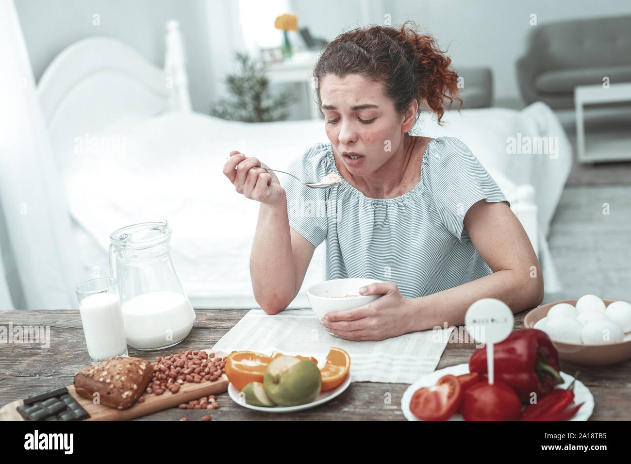 Donna con allergia ad alcuni ingredienti durante la prima colazione Foto Stock