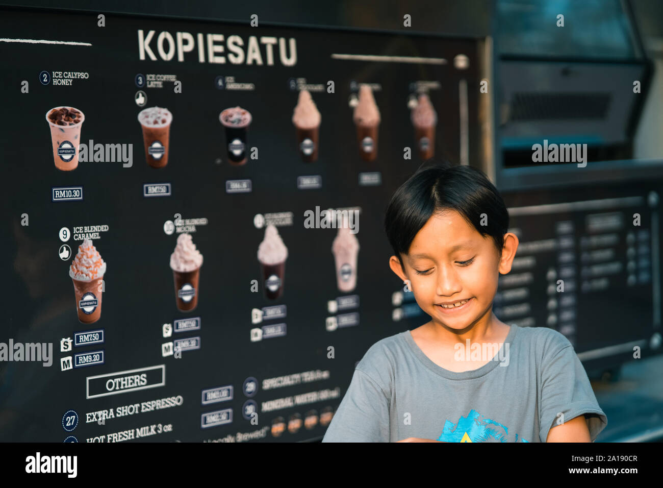 Putrajaya, Malesia - 6 Settembre 2019 : Giovane ragazzo in attesa di bevande al cioccolato al cibo Kopiesatu carrello la vendita di caffè. Foto Stock