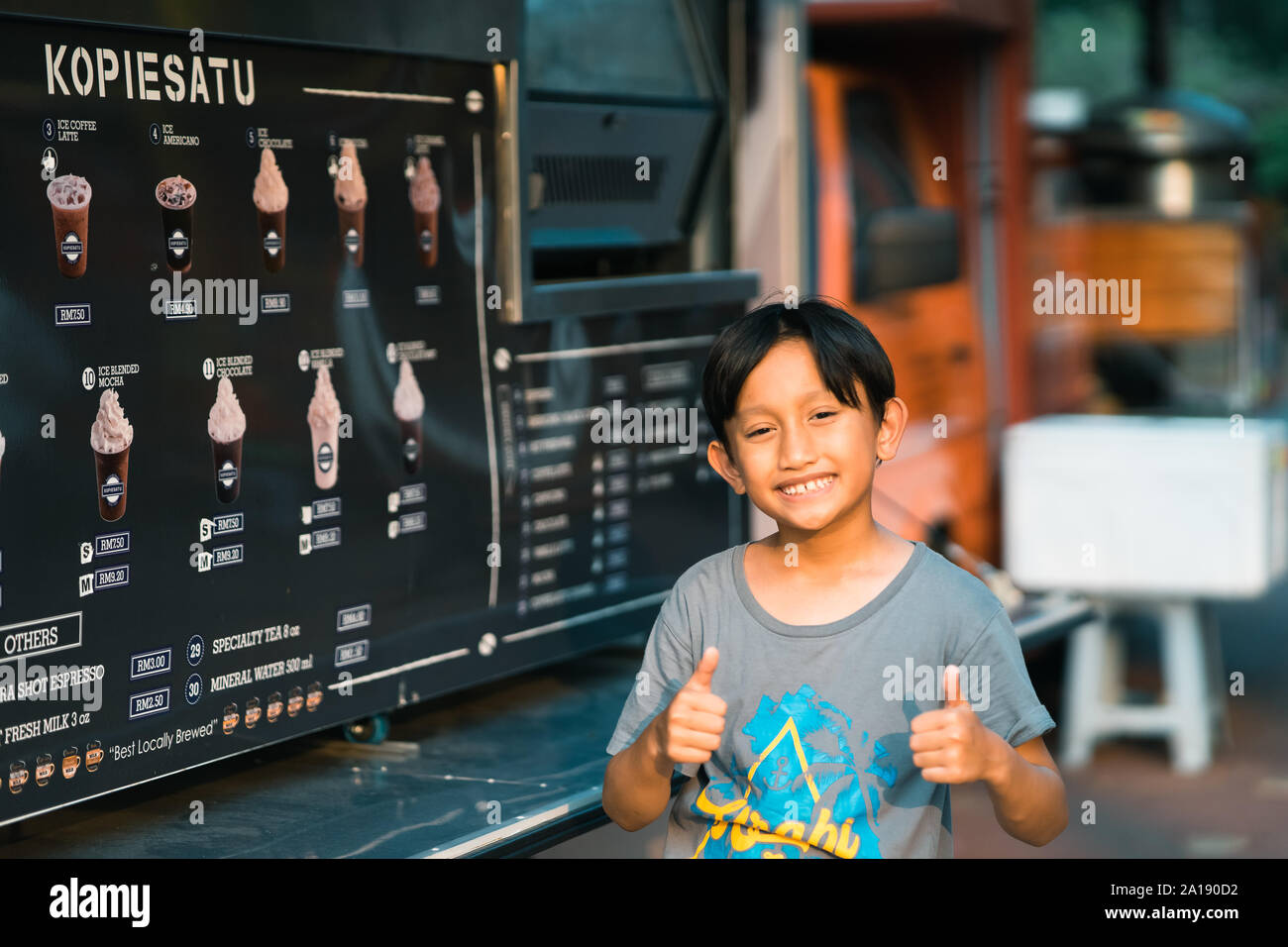 Putrajaya, Malesia - 6 Settembre 2019 : Giovane ragazzo in attesa di bevande al cioccolato al cibo Kopiesatu carrello la vendita di caffè. Foto Stock