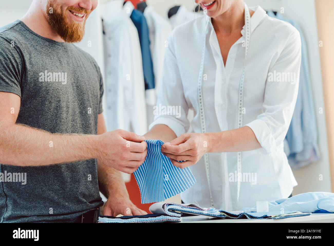 Sarto e cliente la scelta di materiale per la camicia dal pattern book Foto Stock