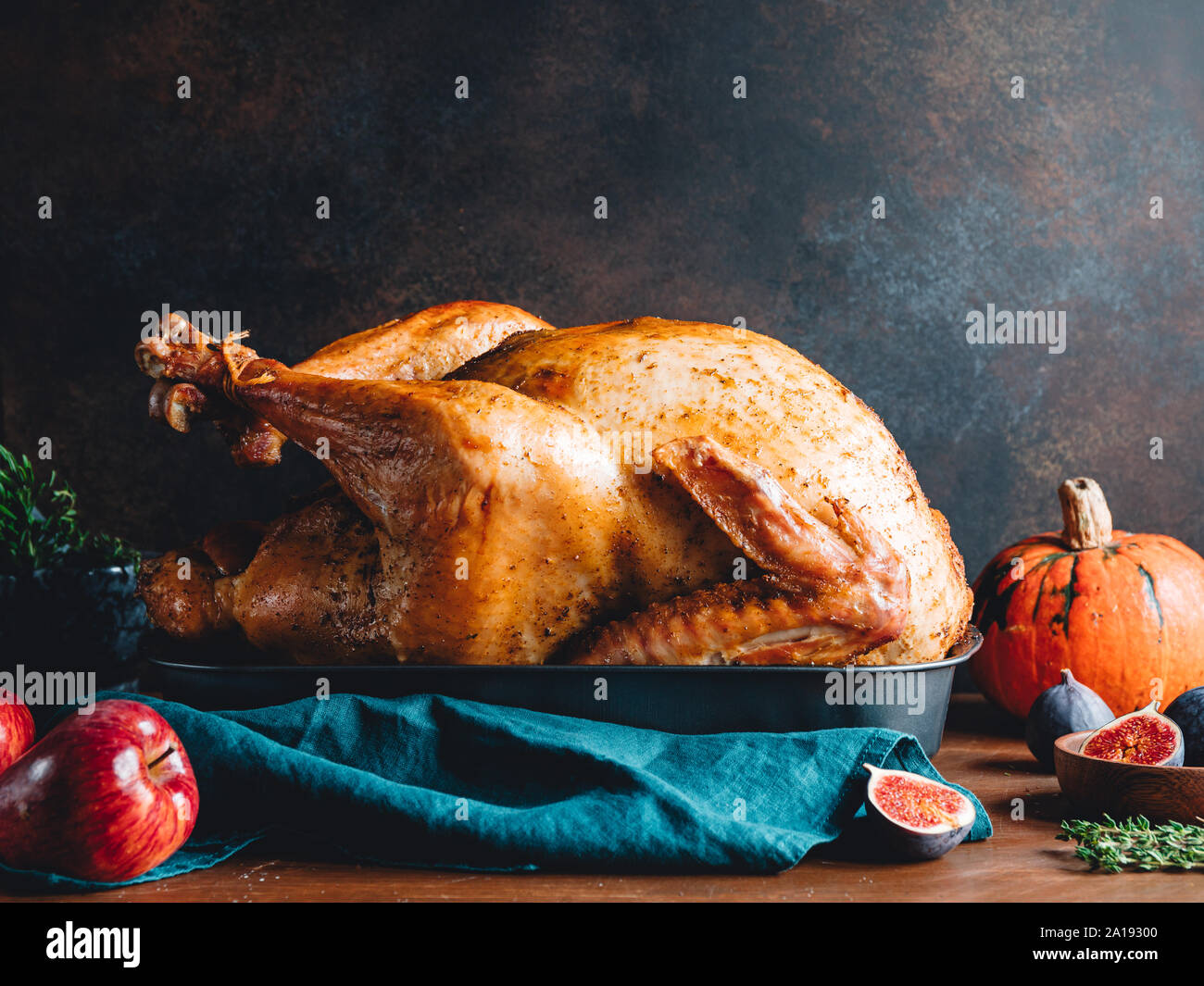 Arrosto di tacchino intero su un tavolo con Apple, la zucca e le figure per la famiglia per la Festa del Ringraziamento. Foto Stock