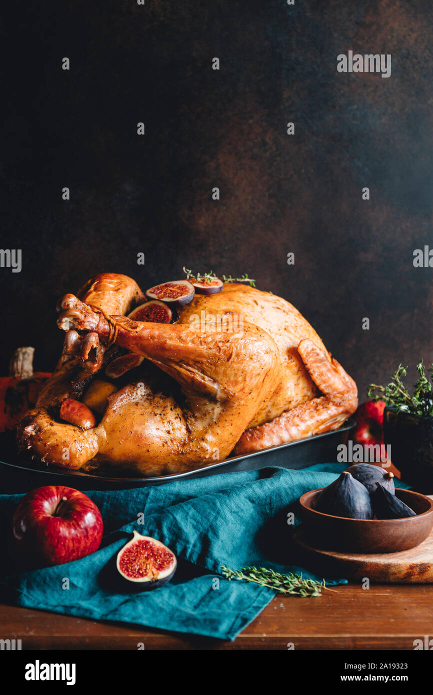 Arrosto di tacchino intero su un tavolo con Apple, la zucca e le figure per la famiglia per la Festa del Ringraziamento. Foto Stock
