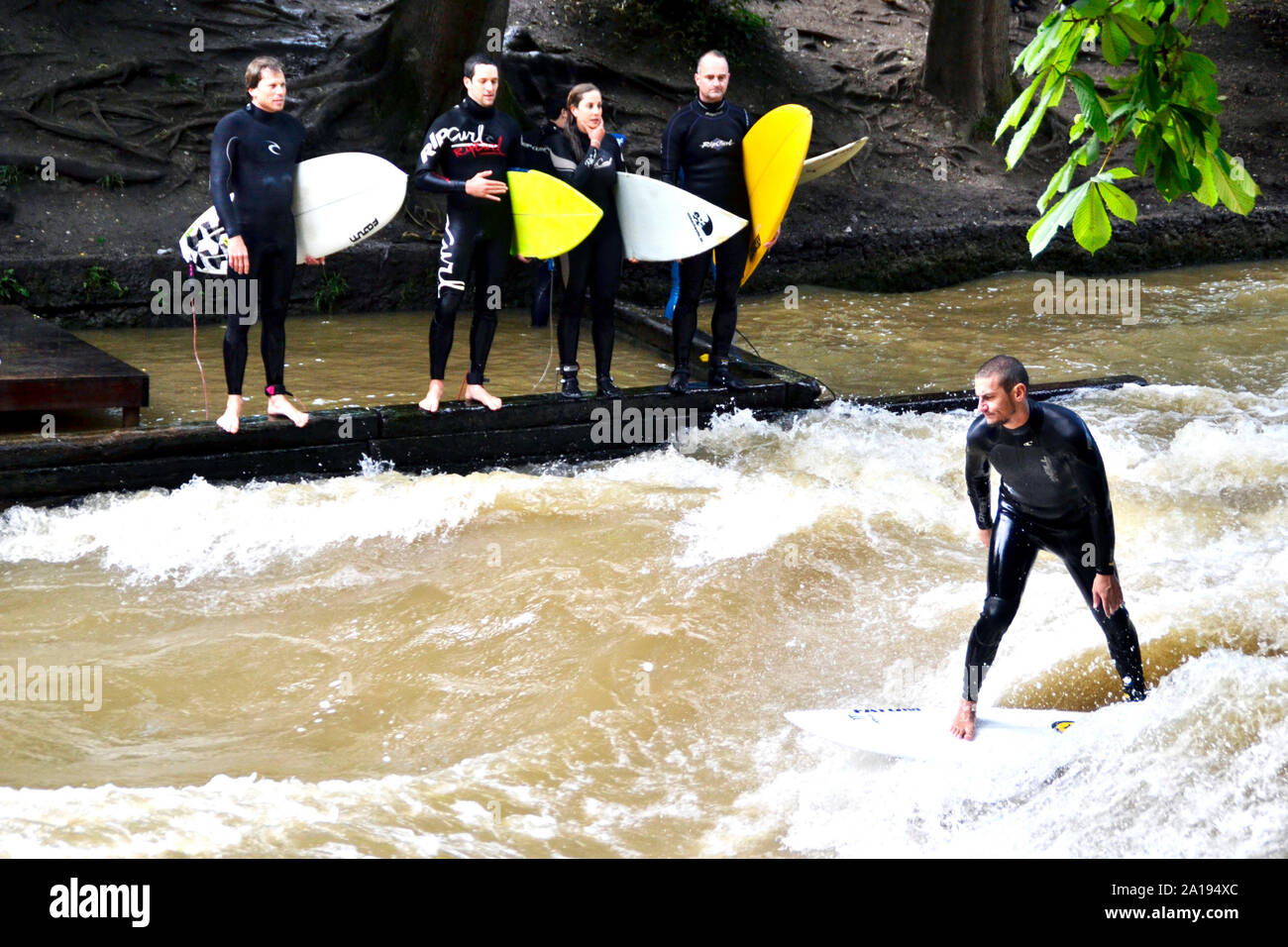 Monaco di Baviera / Germania - Luglio 13, 2019: Surfer Cavalca le onde artificiali sul Eisbach, un piccolo fiume a Monaco di Baviera. Foto Stock