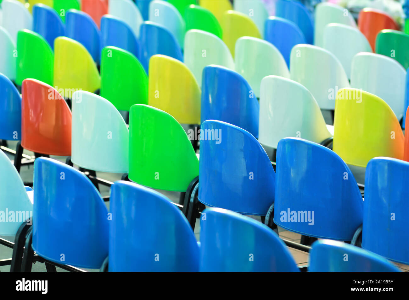 Righe di colorate sedie di plastica da giardino, vista posteriore Foto Stock
