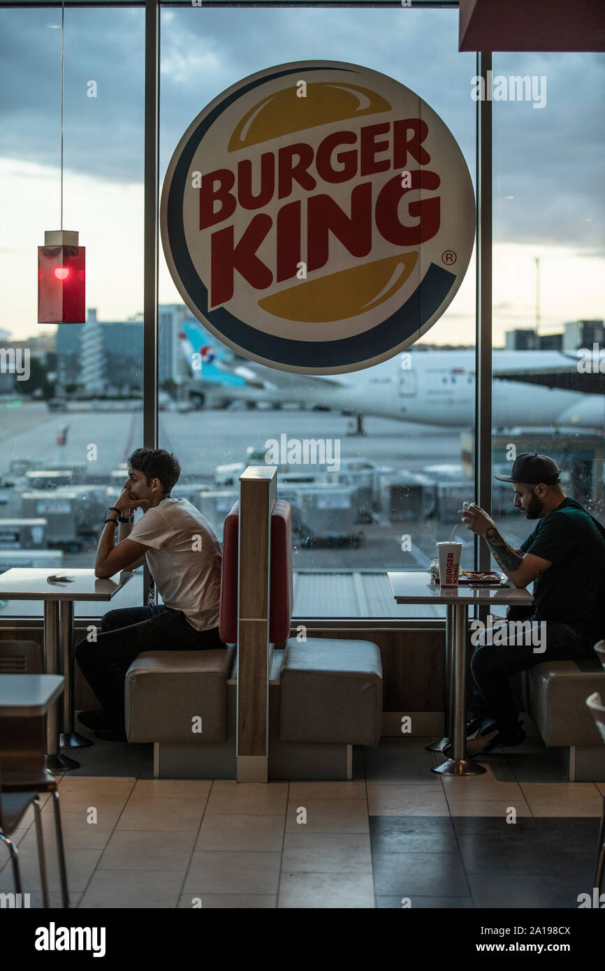 Burger King, persone sedersi a mangiare all'interno di fast food che si affaccia dall' aeroporto di Barajas, Madrid, Spagna, Europa Foto Stock