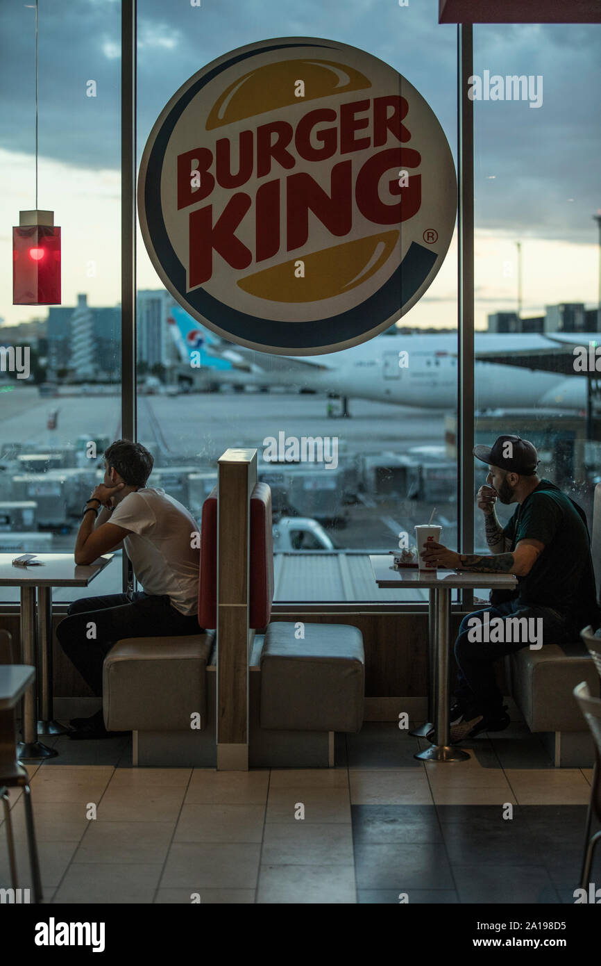 Burger King, persone sedersi a mangiare all'interno di fast food che si affaccia dall' aeroporto di Barajas, Madrid, Spagna, Europa Foto Stock