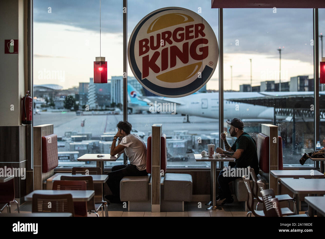 Burger King, persone sedersi a mangiare all'interno di fast food che si affaccia dall' aeroporto di Barajas, Madrid, Spagna, Europa Foto Stock