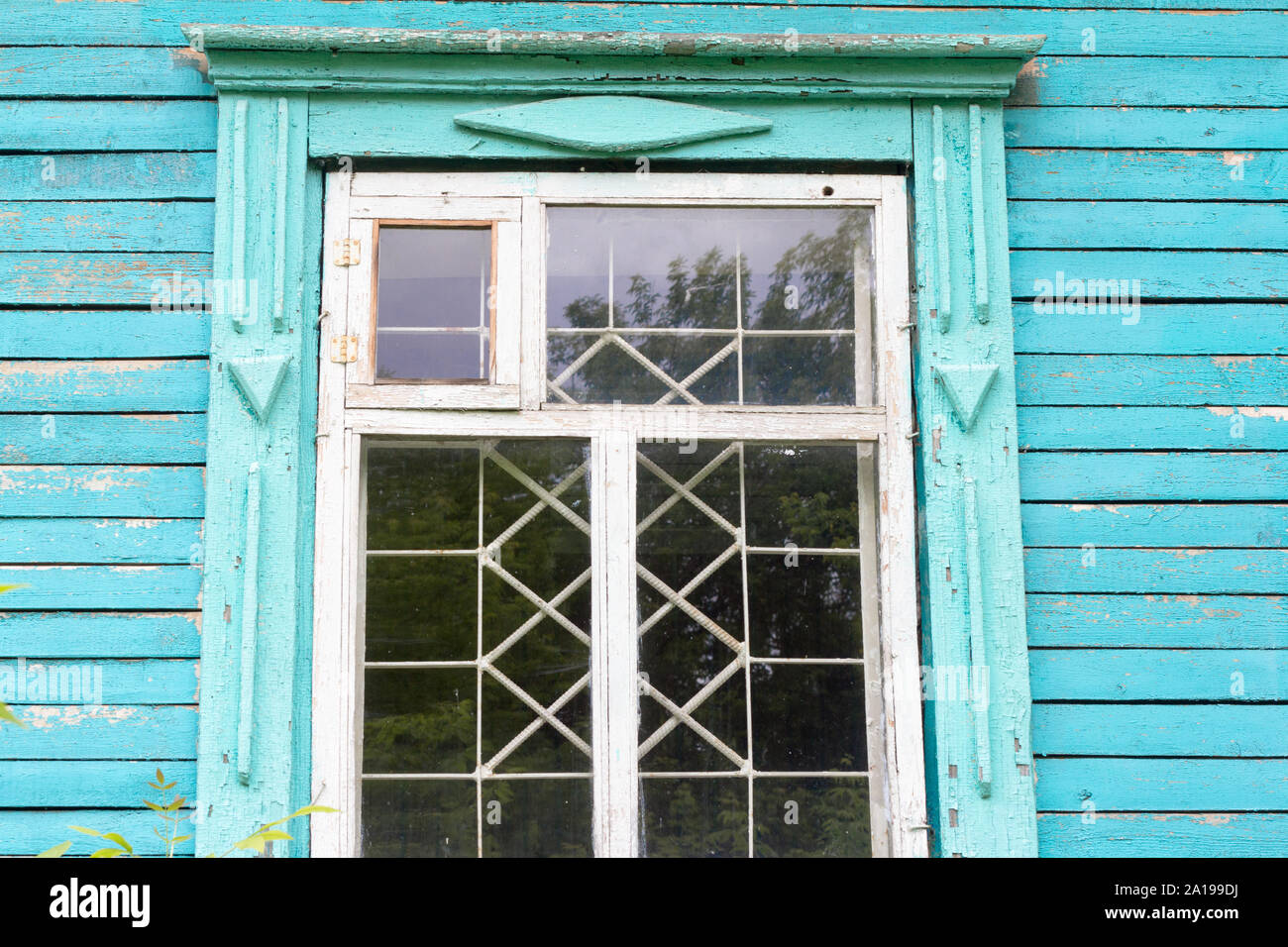 Vecchia finestra in legno con barre di ferro in un abbandonato casa in legno Foto Stock