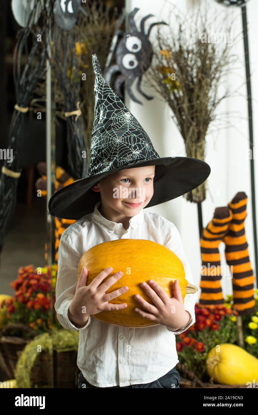 Halloween piccolo ragazzo in spider web hat a calze a strisce. Il capretto con zucca arancione in witch hat. Vacanze e di celebrazione. Party e cibi tradizionali. Hal Foto Stock