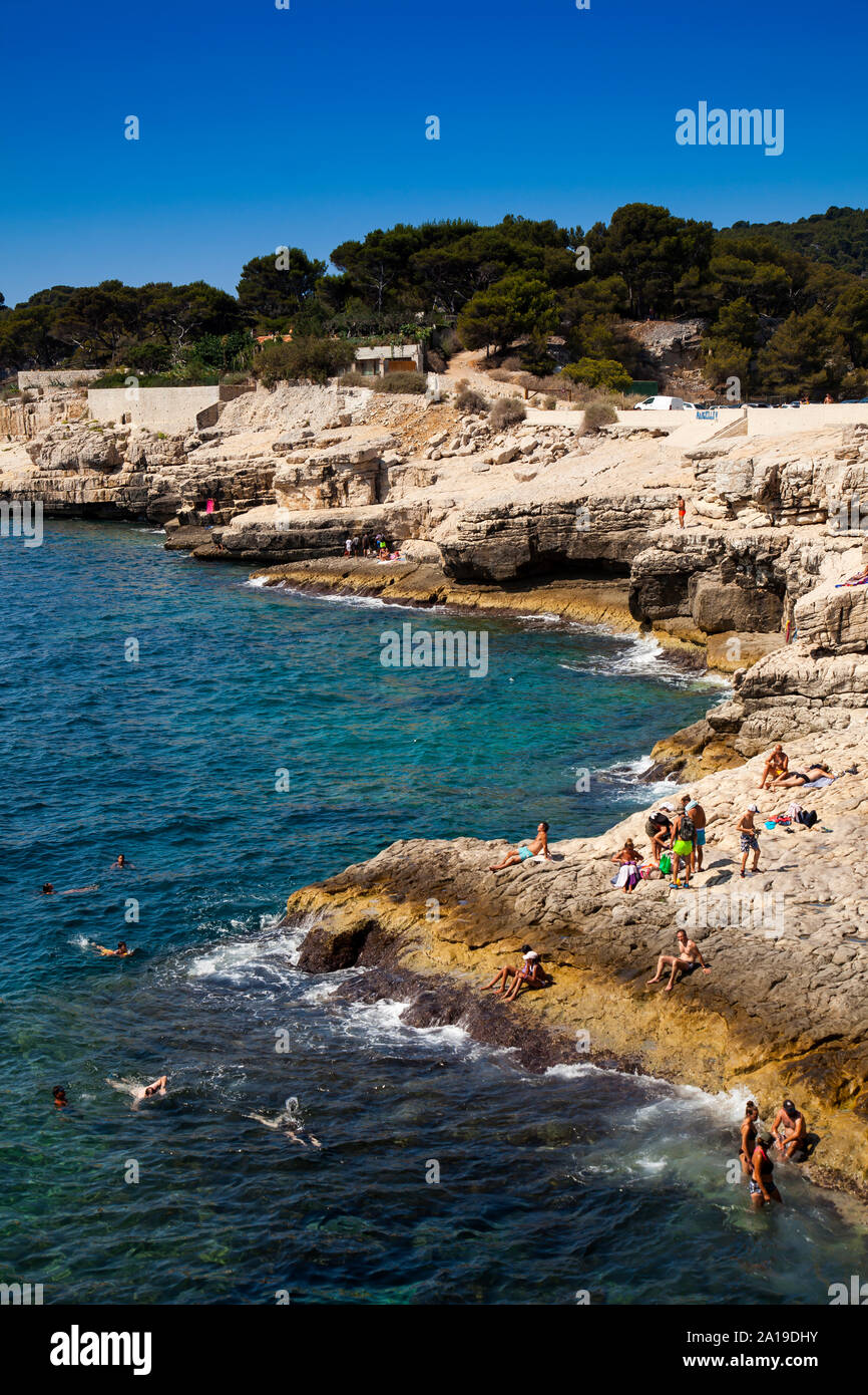 Persone nuotare presso la costa rocciosa di Calanque de Port Pin, Provence, Francia Foto Stock