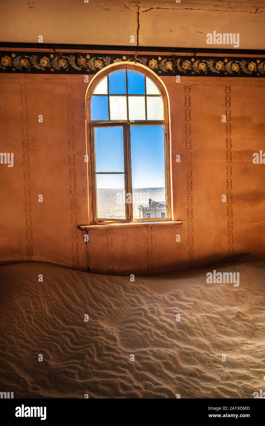 Stanza vuota con una finestra e la sabbia in le rovine di una città fantasma Kolmanskop, Namibia Foto Stock