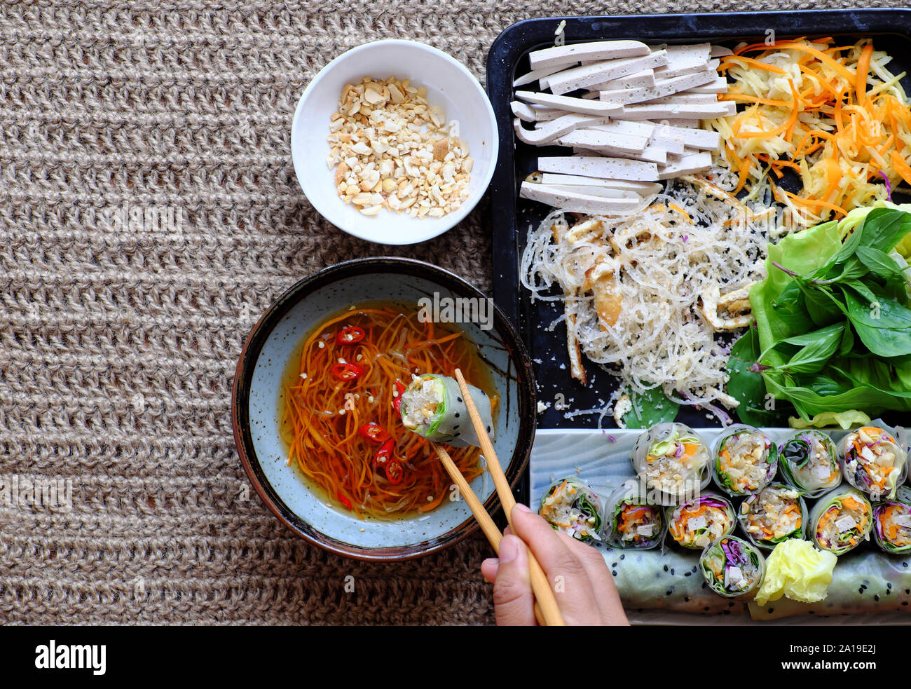 Vista superiore persone mangiare vegetariano a fette carta in rotoli di riso con salsa di verdure colorate rendono piatto vegano che sana e deliziosa Foto Stock