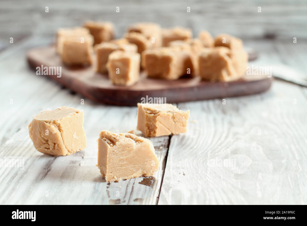 Piazze di deliziosi piatti fatti in casa, burro di arachidi fudge su una tavola in legno rustico. Messa a fuoco selettiva su candy in primo piano con sfondo sfocato. Foto Stock