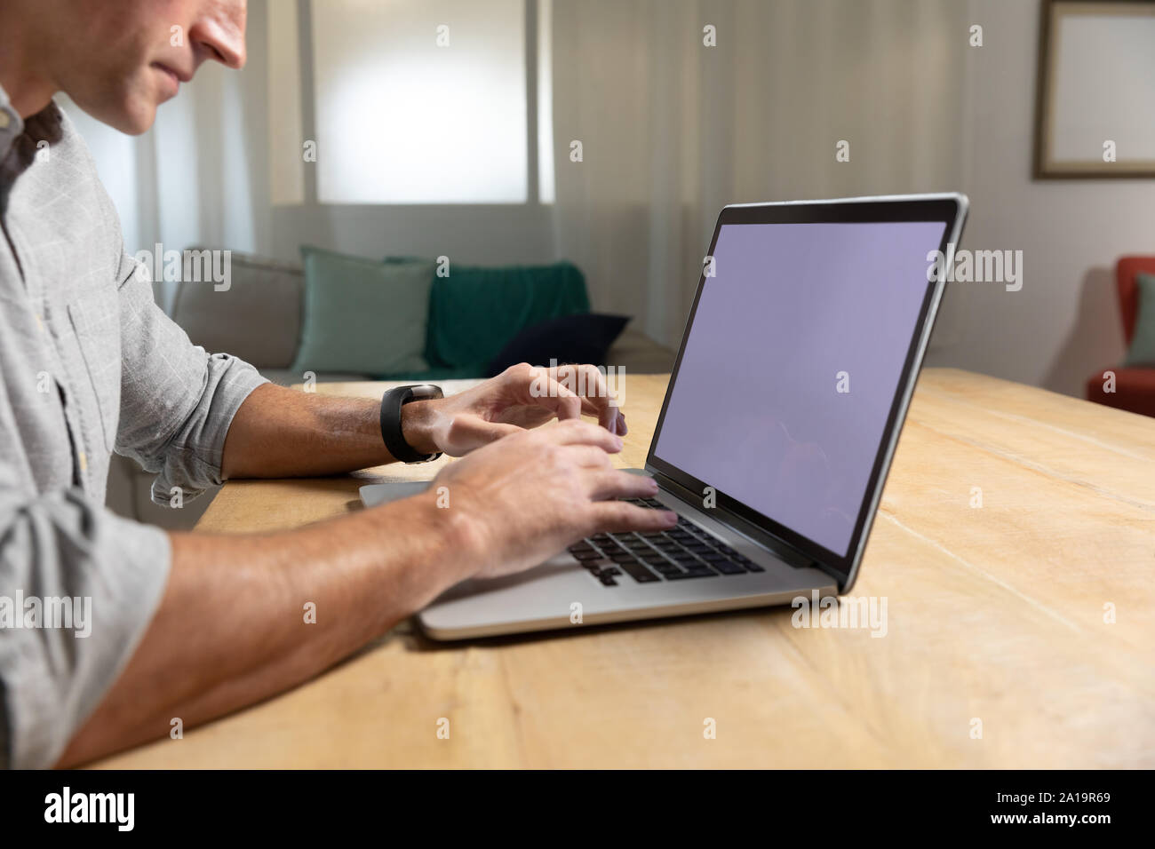 Giovane uomo utilizzando il computer portatile su un tavolo Foto Stock