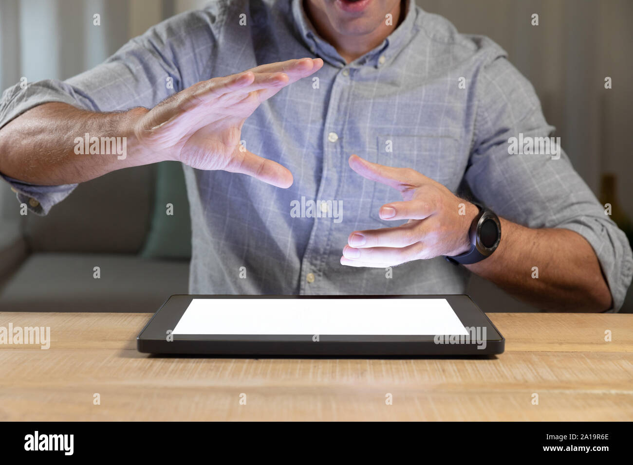Giovane uomo utilizzando computer tavoletta su un tavolo Foto Stock