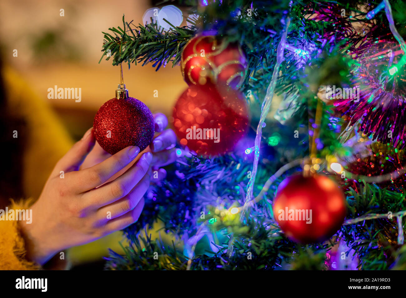 Donna decorare albero di Natale Foto Stock