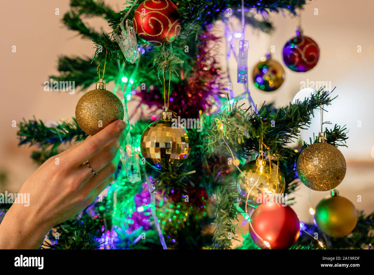 Donna millenario decorare albero di Natale a casa Foto Stock