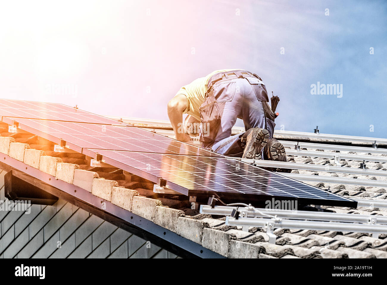 Installazione solare pannello fotovoltaico sistema. Pannello solare tecnico installazione di pannelli solari sul tetto. L'energia alternativa concetto ecologico. Foto Stock