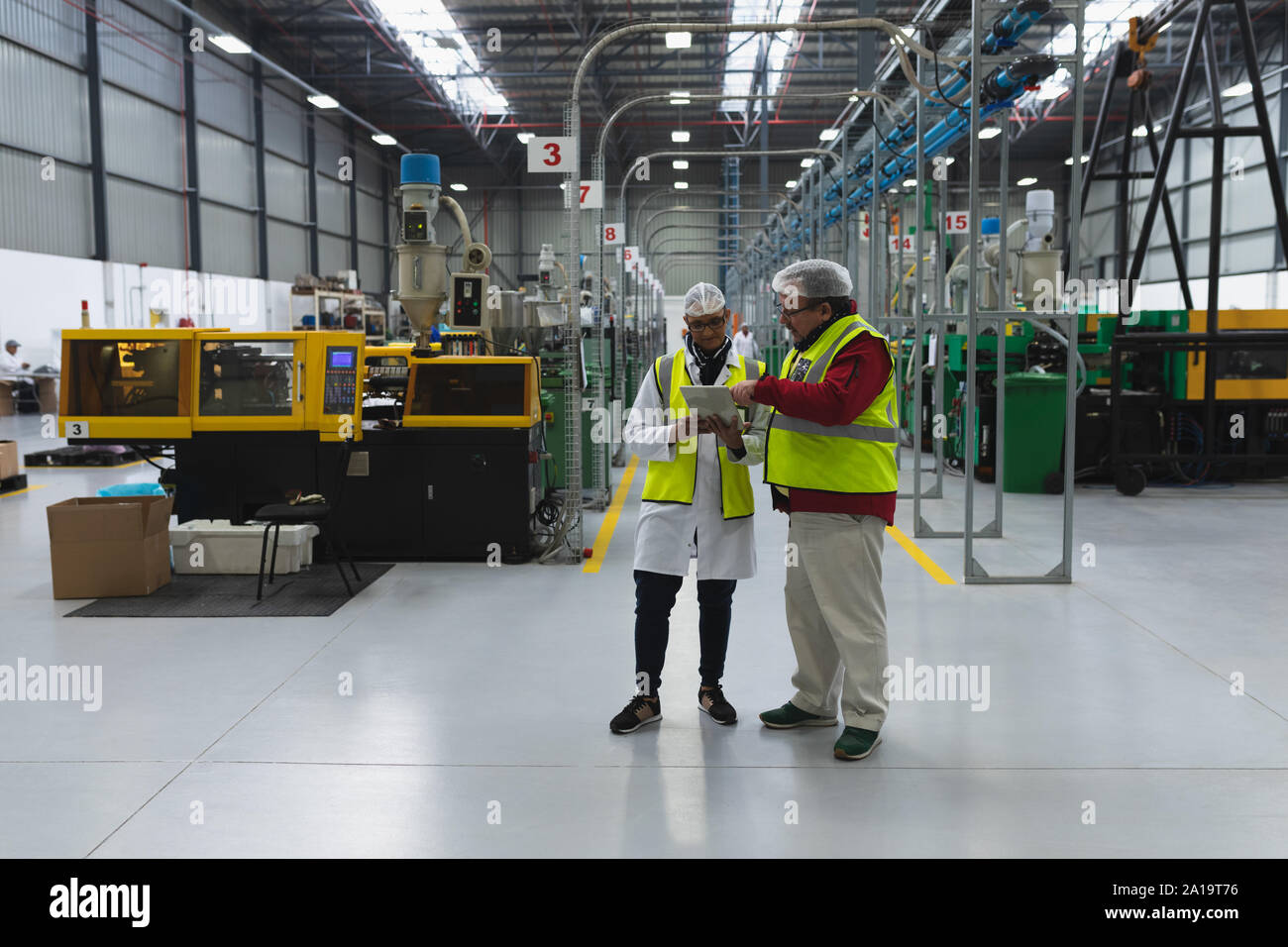 Lavoratori in fabbrica in un magazzino di fabbrica Foto Stock Lavoratori in fabbrica in un magazzino di fabbrica Foto Stock