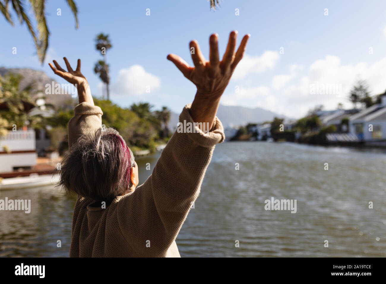 Senior donna godendo il suo tempo libero da un lago Foto Stock