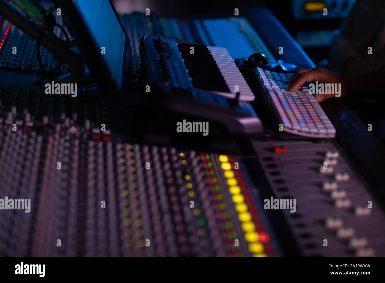 Maschio produttore musicale il lavoro presso il banco di miscelazione in un sound studio Foto Stock