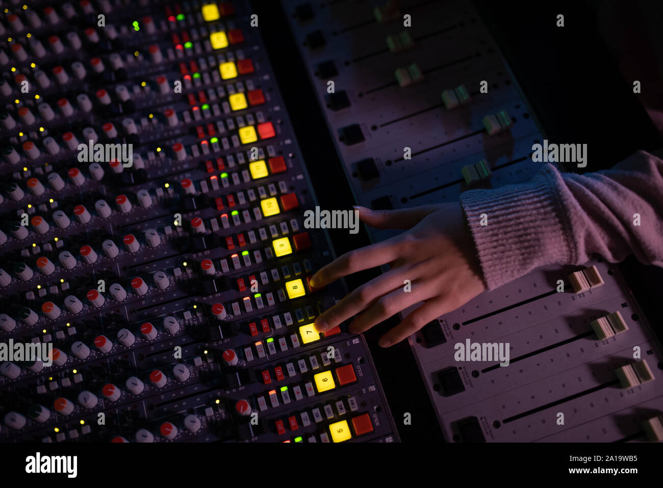 Femmina produttore musicale il lavoro presso il banco di miscelazione in un sound studio Foto Stock