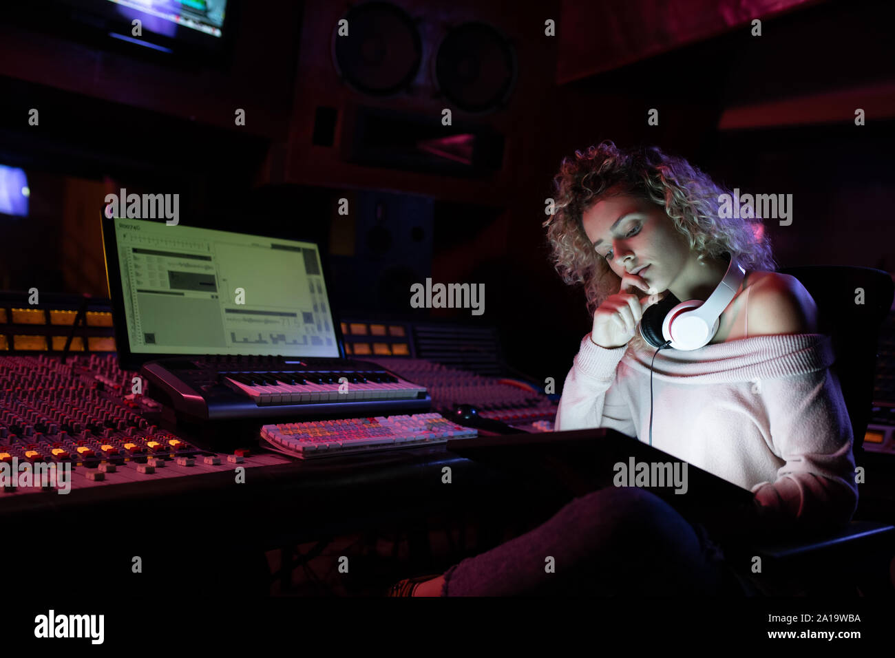 Femmina produttore musicale lavorando in un sound studio Foto Stock