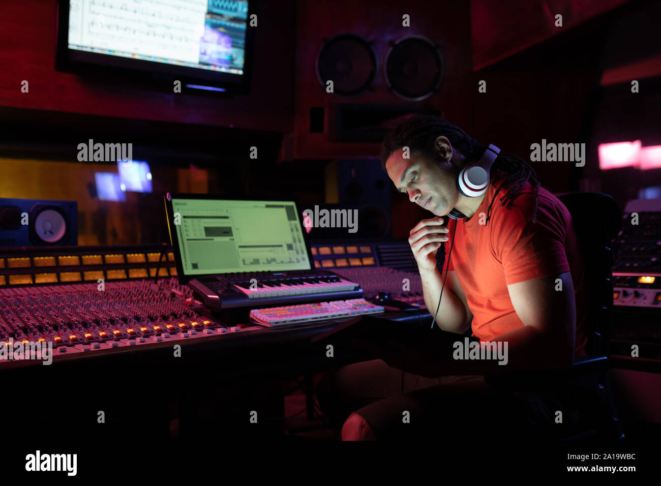 Maschio produttore musicale lavorando in un sound studio Foto Stock