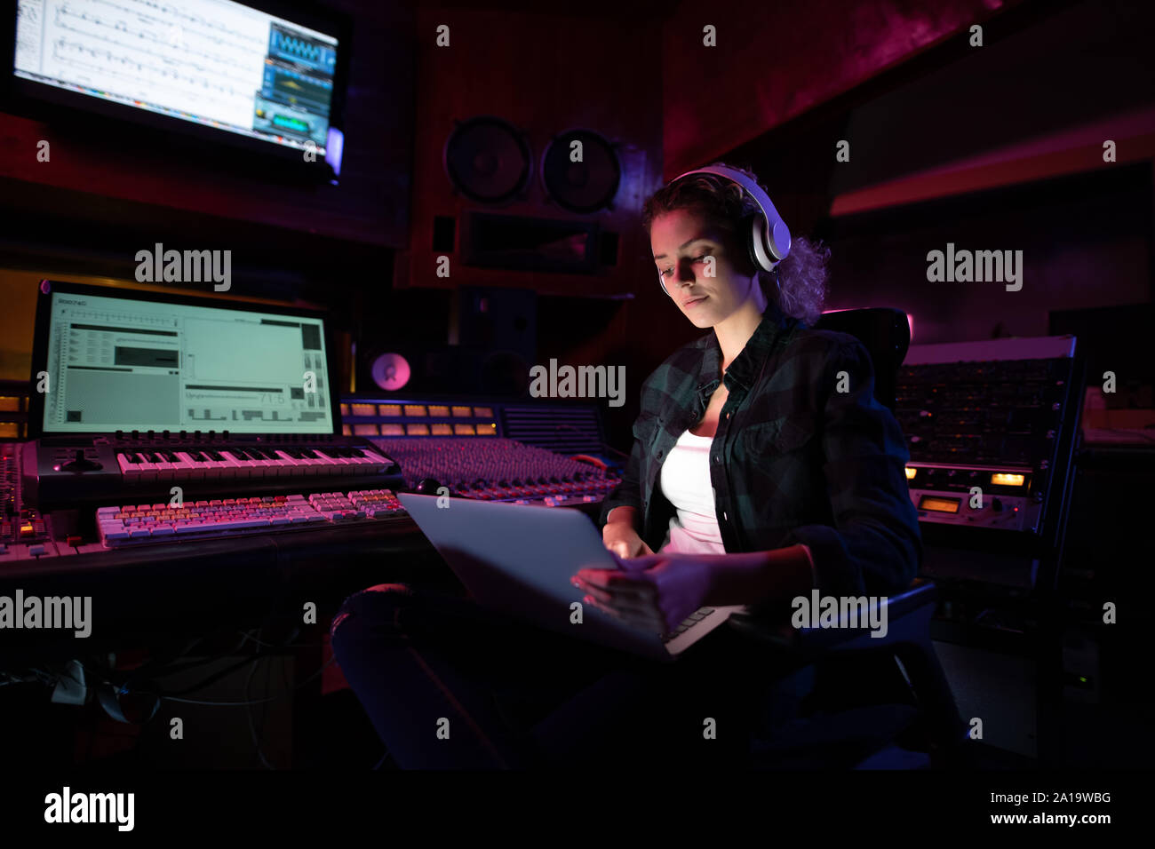 Femmina produttore musicale lavorando in un sound studio Foto Stock