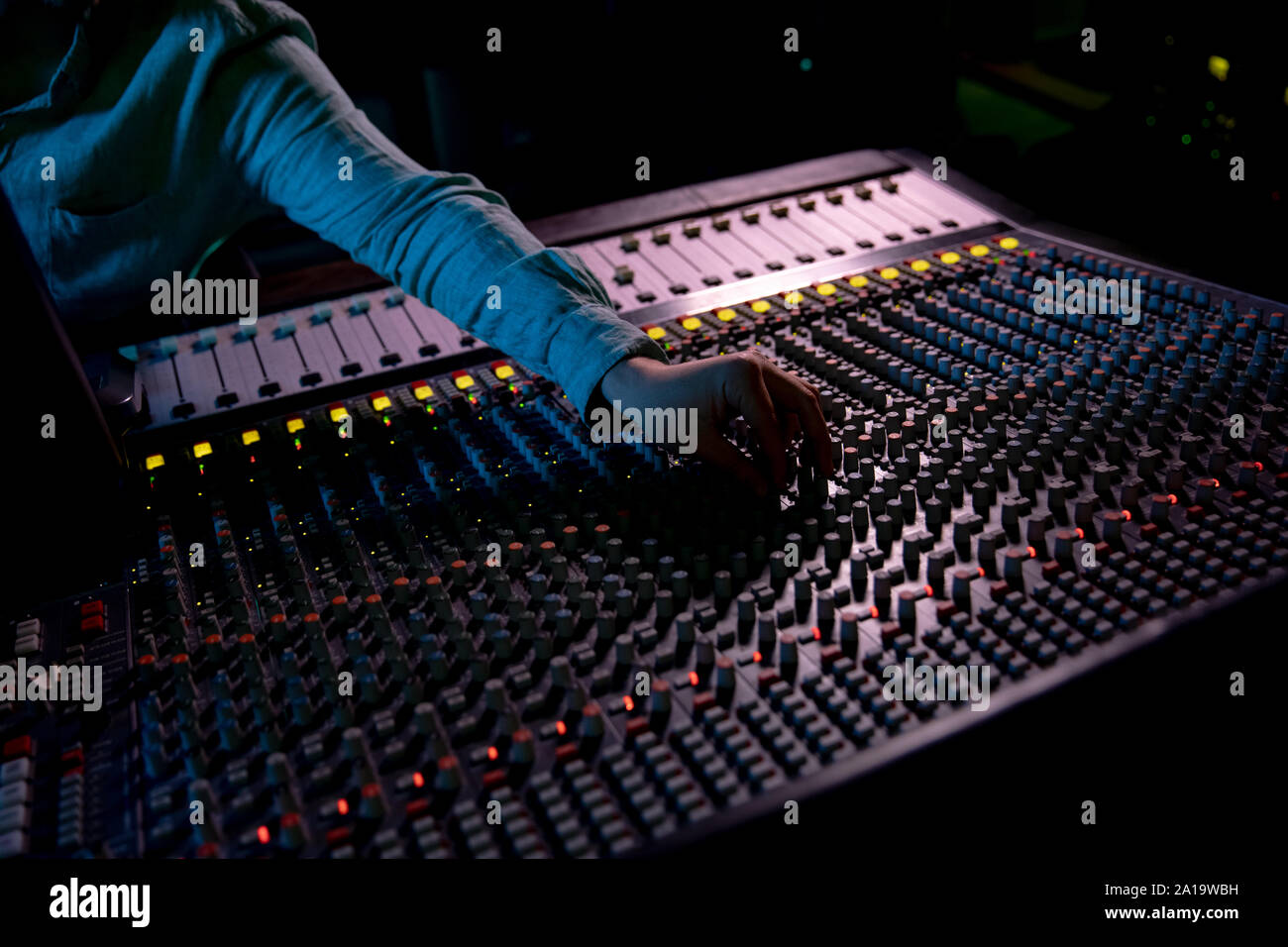 Maschio produttore musicale il lavoro presso il banco di miscelazione in un sound studio Foto Stock