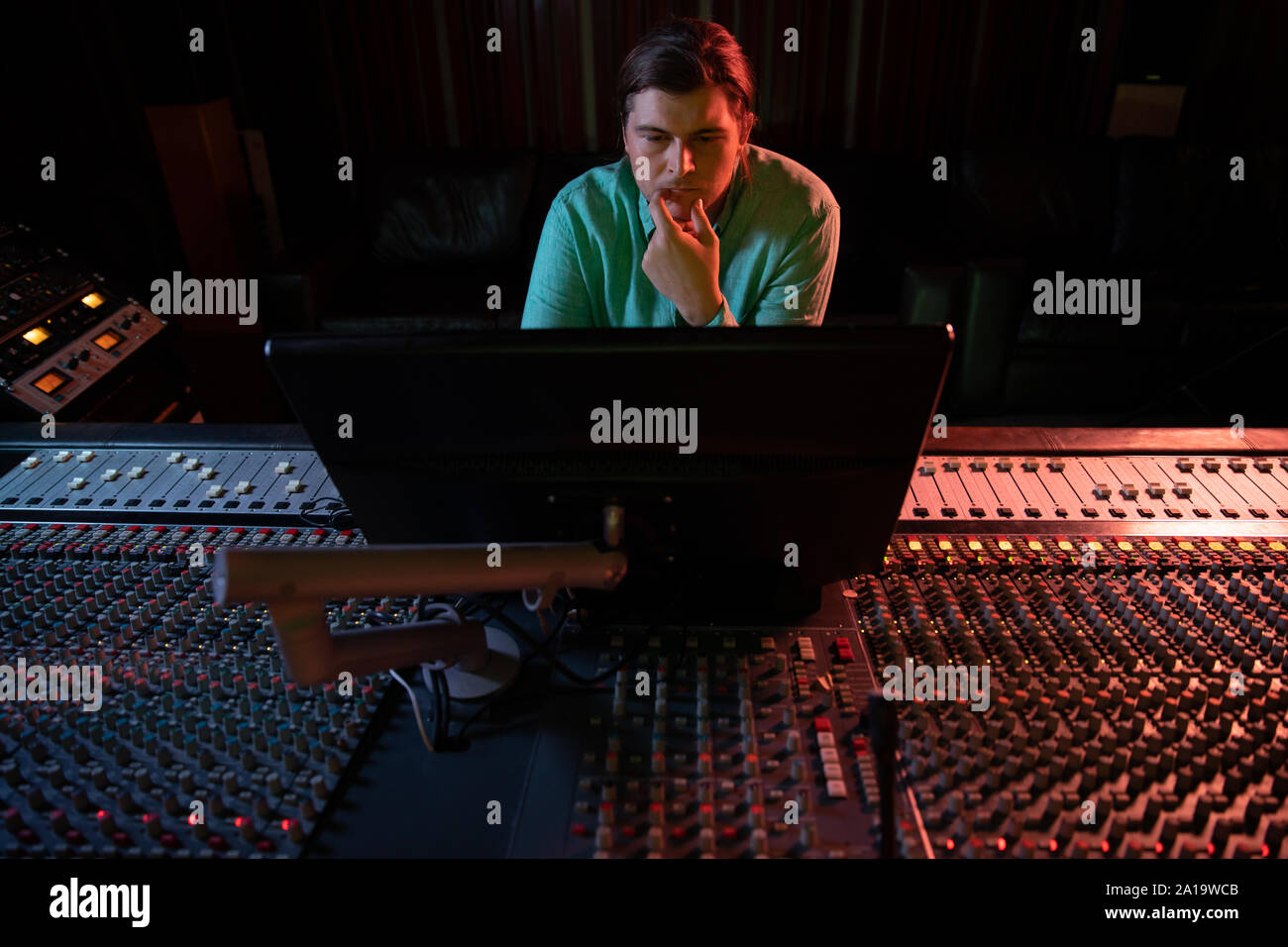 Maschio produttore musicale il lavoro presso il banco di miscelazione in un sound studio Foto Stock