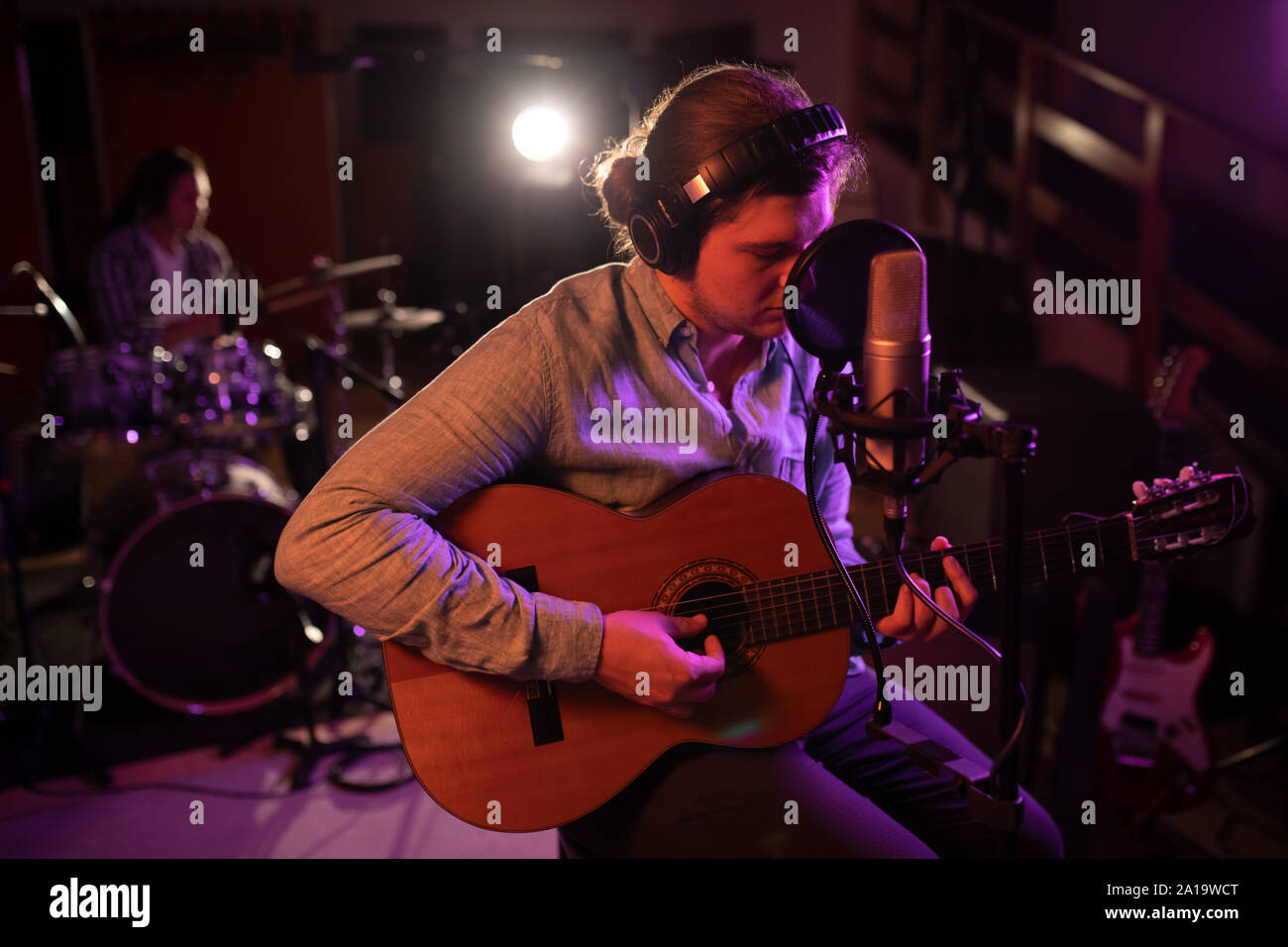 Cantante e chitarrista batterista giocando in un sound studio Foto Stock