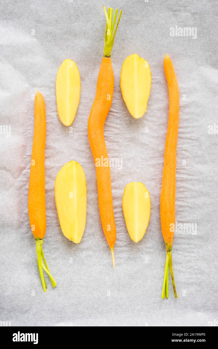 Carote e patate su carta pergamena preparato per la cottura alla griglia in stufa Foto Stock