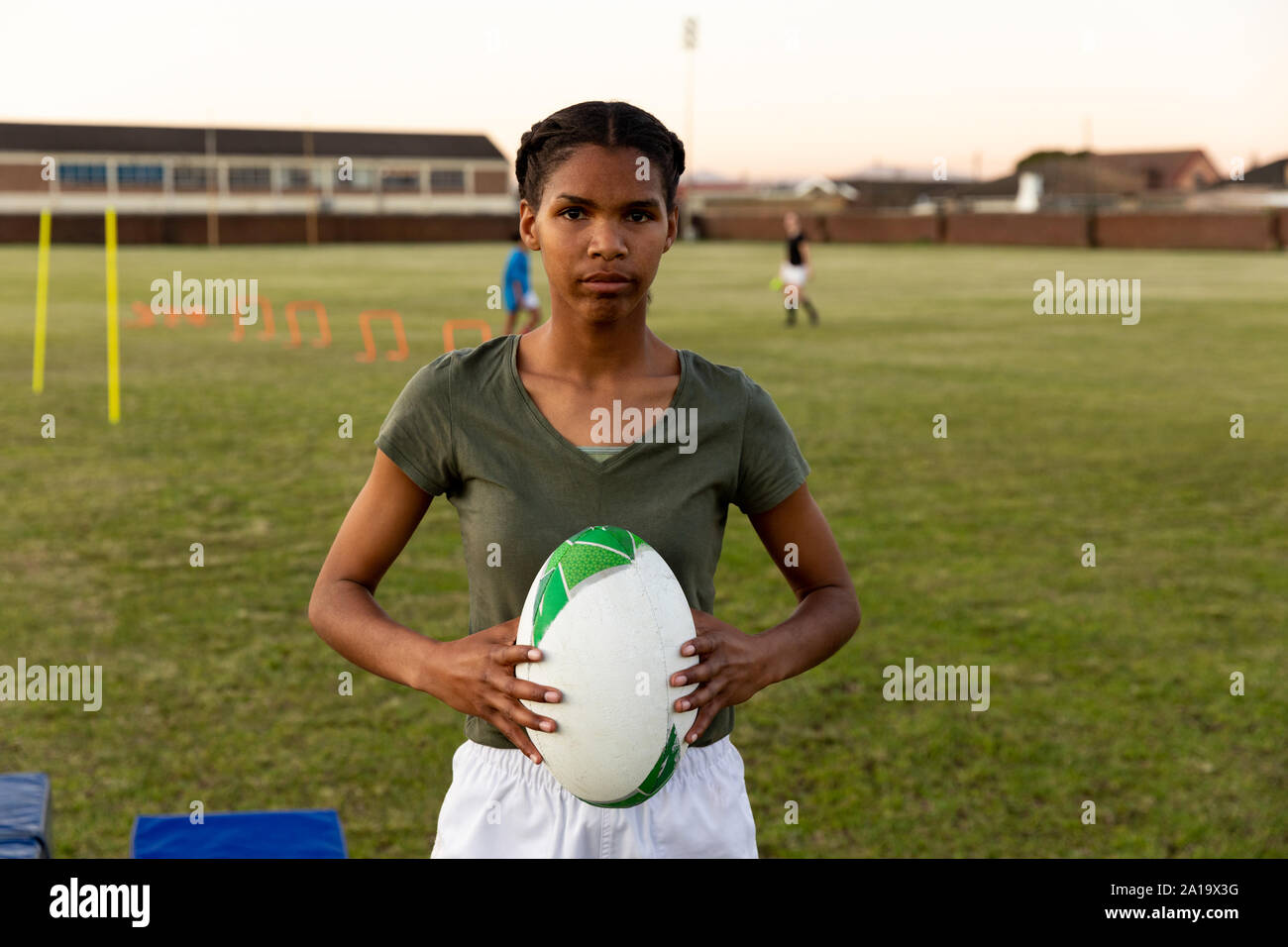 Ritratto di giovane femmina adulta del giocatore di rugby su un passo di rugby Foto Stock
