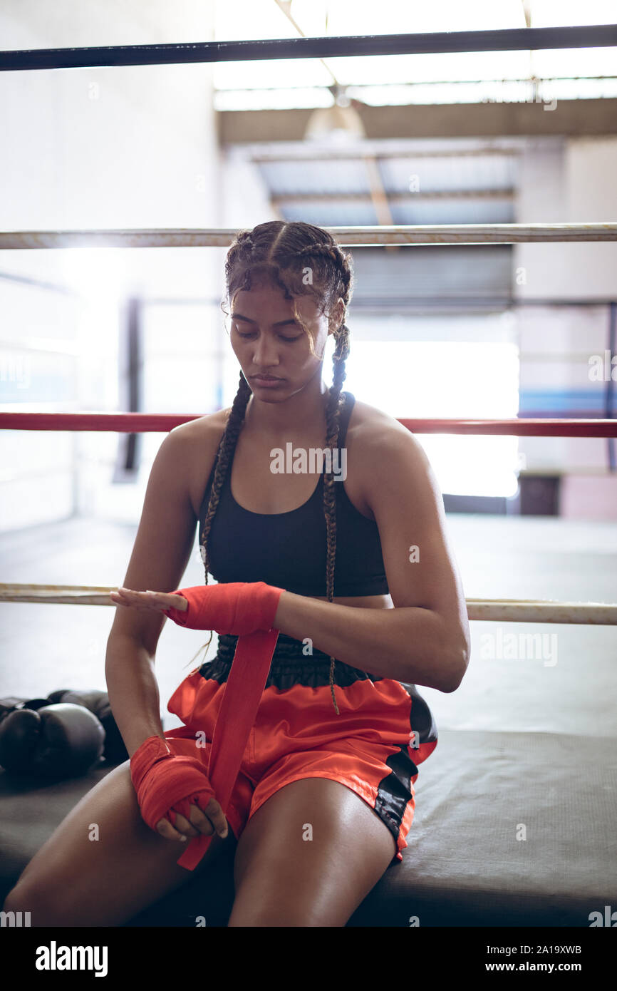 Boxer femmina indossando avvolgere a mano a boxing club Foto Stock