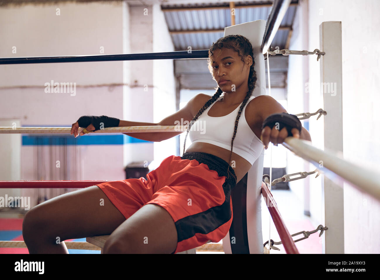 Boxer femmina rilassante nel pugilato ring al centro fitness Foto Stock