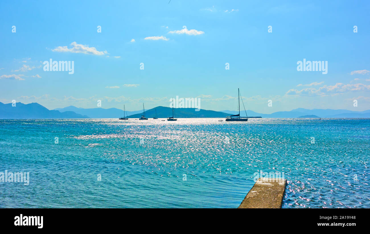 Seascape panoramico con barche a vela in mare nei pressi di Aegina Island in estate a mezzogiorno, Isole Saroniche, Grecia Foto Stock