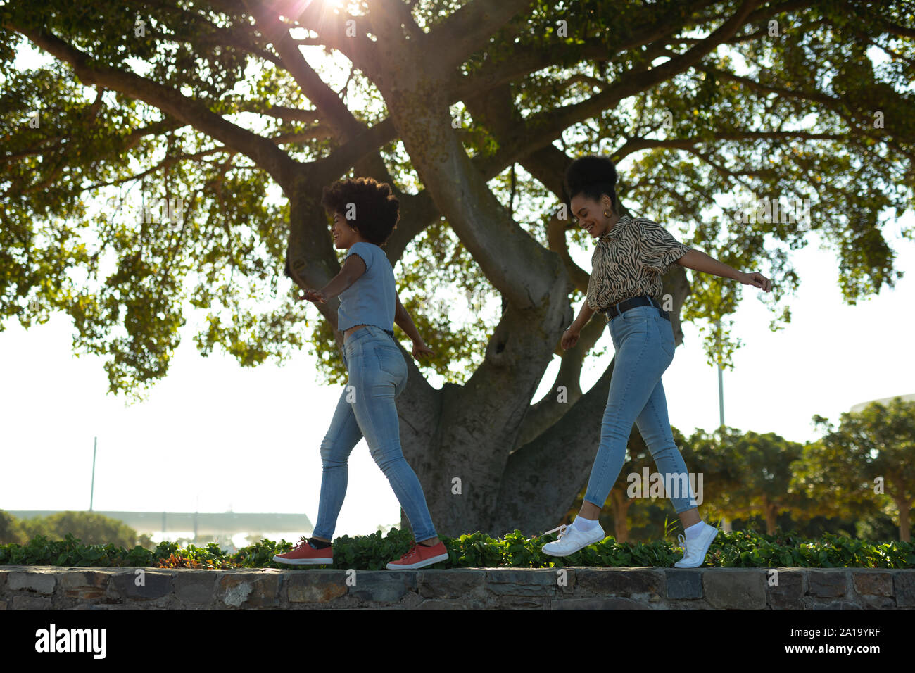 Due giovani donne a camminare su una parete Foto Stock