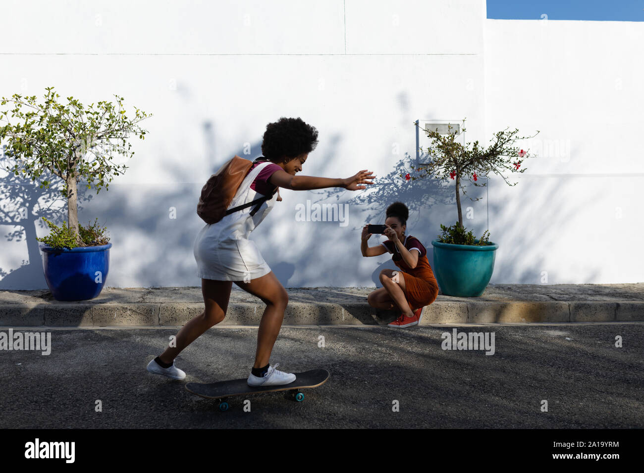 Giovane donna cavallo su skateboard in strada Foto Stock