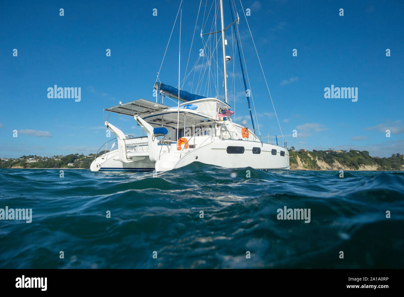 Leopard catamarano ancorato vicino alla riva, stern visto dalla linea di acqua Foto Stock