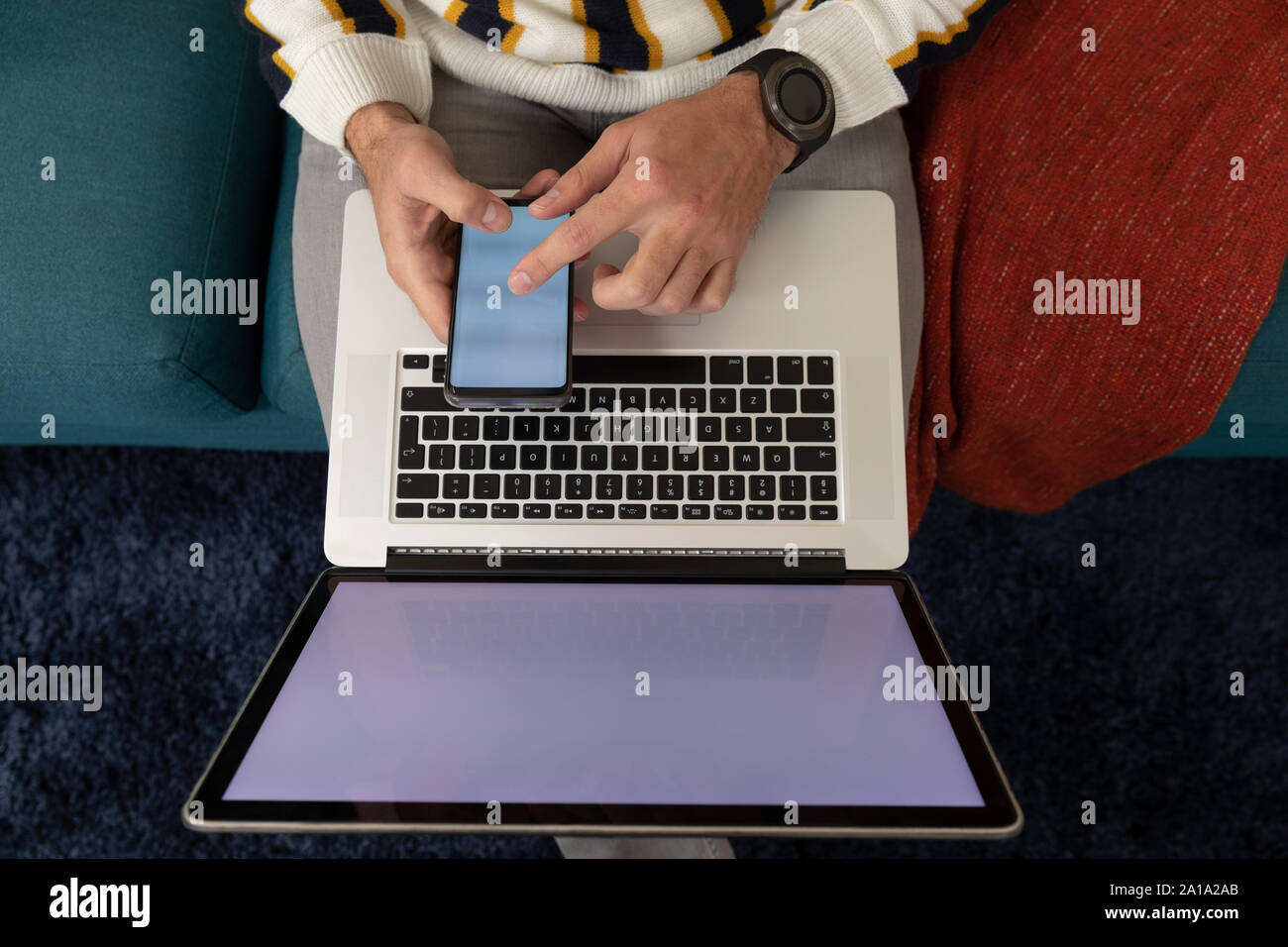 Uomo che utilizza lo smartphone e il computer portatile Foto Stock